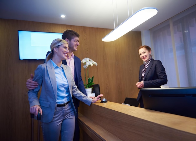 Couple on a business trip doing check-in at the hotel