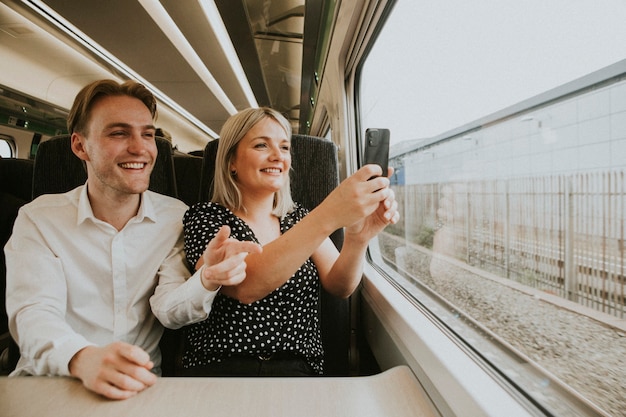 風景写真を撮る電車の窓際のカップル