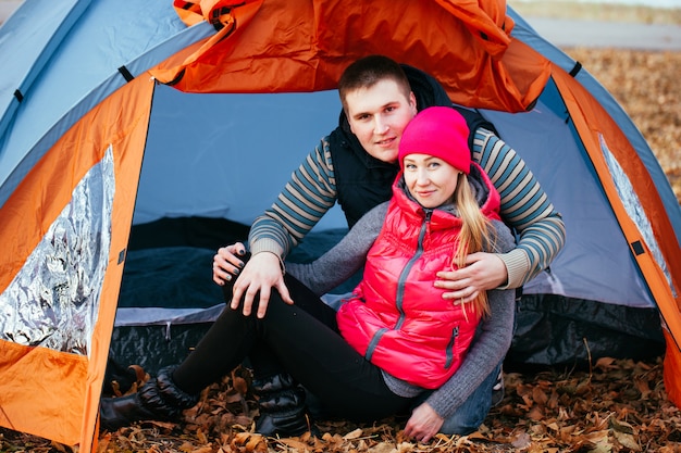 Couple camping. Young couple sitting near the tent.