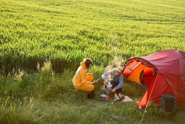 Couple at campsite with tent on a green field