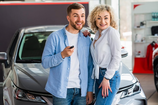 Couple in car dealership near their new car