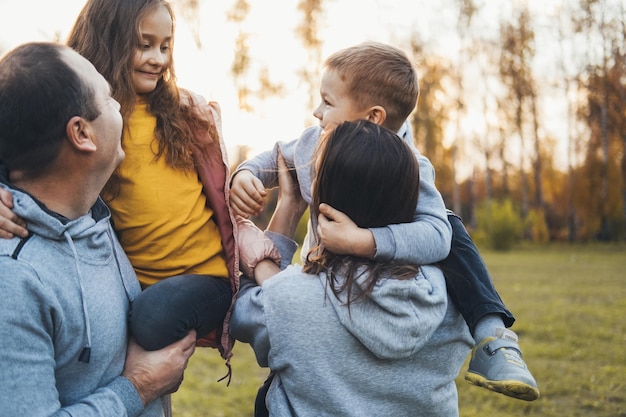 Photo couple carrying two children spending time together family day