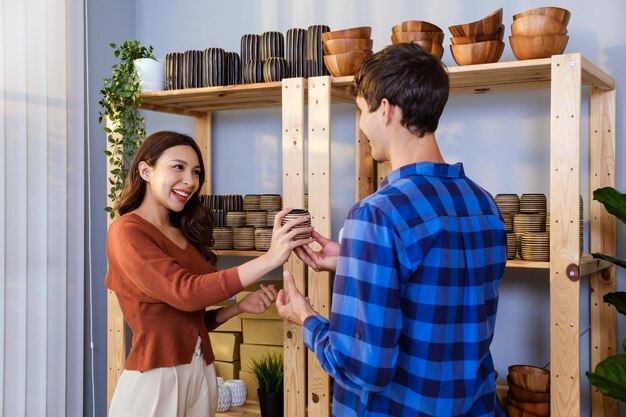 A couple of Caucasian male and Asian female sell vase products online at home Checking vases stock together for send by order to the customers Remote purchase Shopping online concept