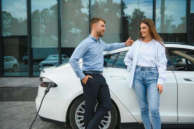 Couple on the charging station for electric vehicles