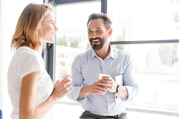 Couple of cheerful colleagues talking