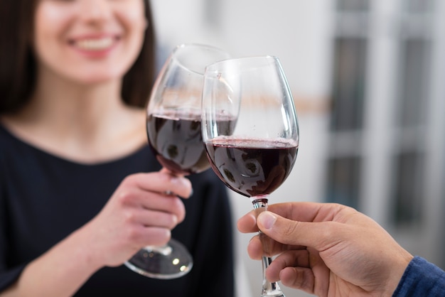 Couple cheering with glasses of wine close-up