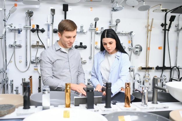 Couple choosing bathroom faucets in plumbing store