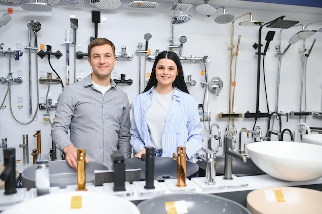 Couple choosing bathroom faucets in plumbing store