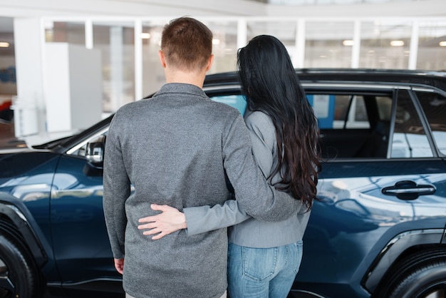 Couple choosing new car in showroom