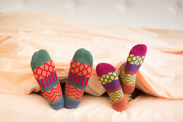 Couple in Christmas socks in bedroom