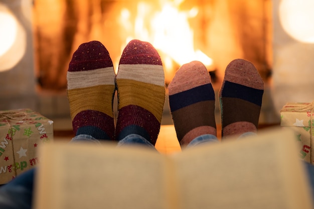 Couple in Christmas socks near fireplace Man and woman having fun together