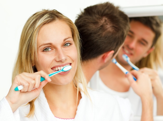 Photo couple cleaning their teeth