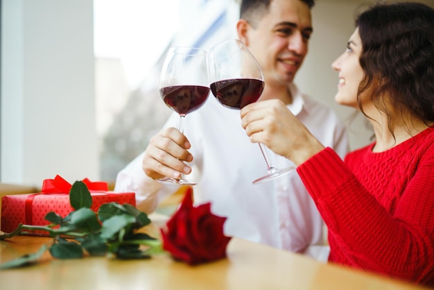 Couple clink glasses with red wine Romance at restaurant for Valentines Day concept