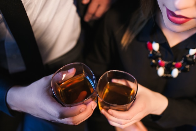 彼らの日付にアルコールとグラスをチリンと鳴らすカップル。セックスをするために女性を酔わせようとしている男性。文字列のない関係の概念