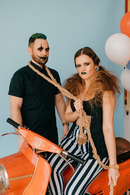 A couple of clowns posing on motorbike