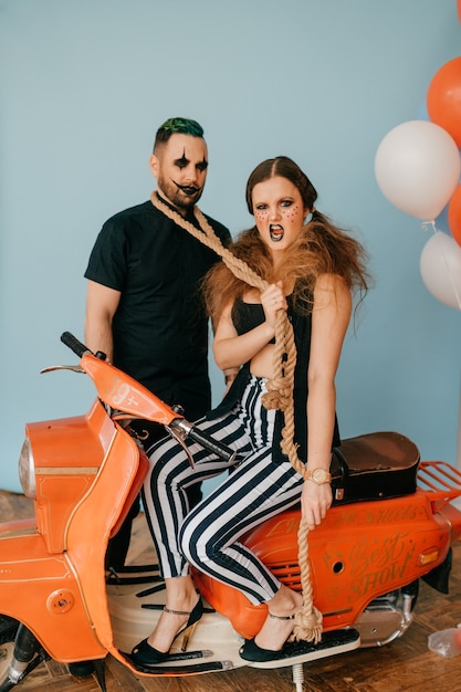 A couple of clowns posing on motorbike