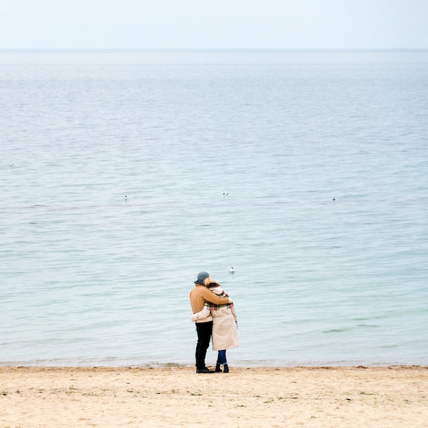 Foto coppia sulla costa a guardare il mare