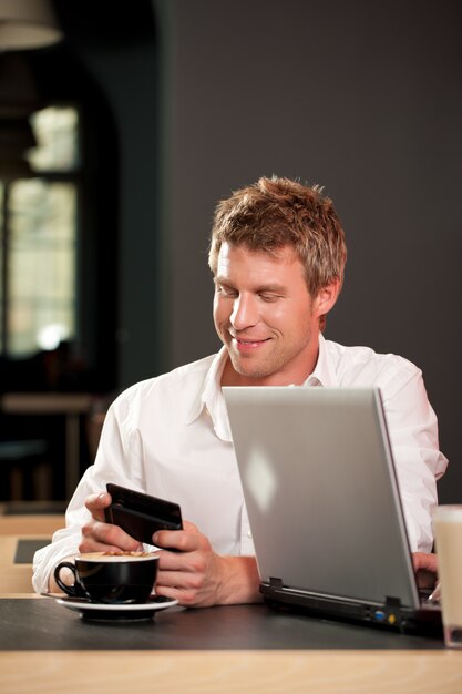 Couple in coffeeshop with laptop and mobile