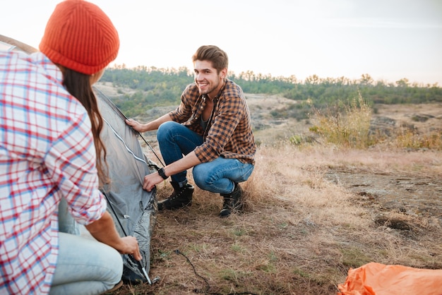 Couple collect tent on mountain