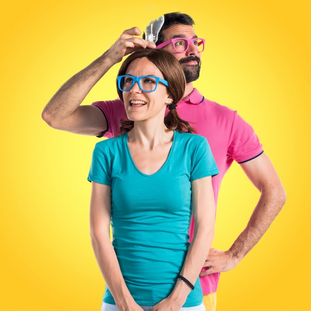 Photo couple in colorful clothes holding a bulb