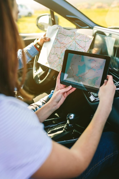 Couple comparing paper map and a gps navigator