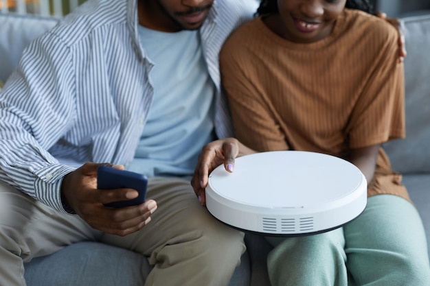 Couple connecting robot vacuum cleaner to smartphone