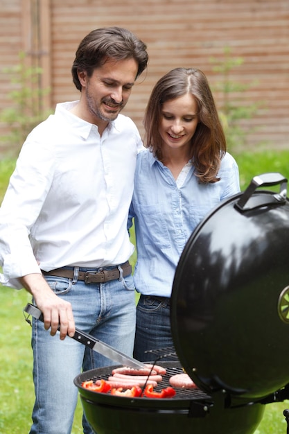 Foto coppie che cucinano sul barbecue