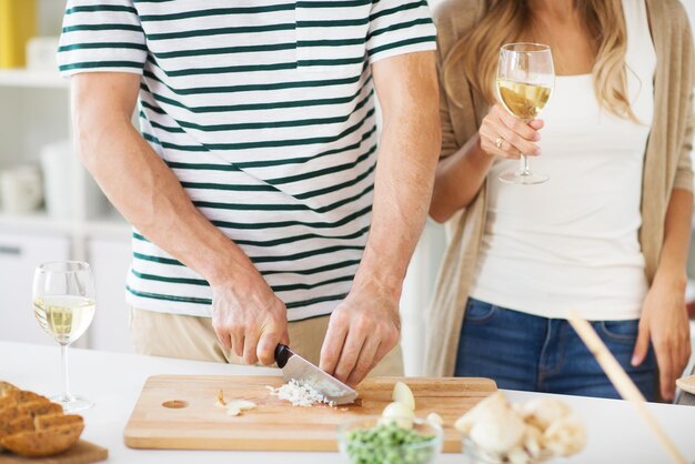 Photo couple cooking food and drinking wine at home