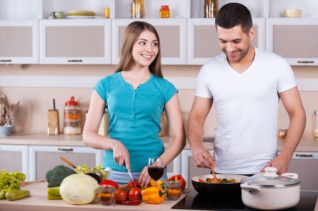 Couple cooking together. Happy young couple cooking together in the kitchen