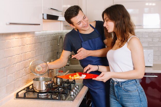 Coppie che cucinano insieme nella cucina a casa