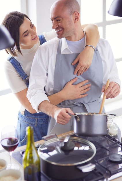 Foto coppie che cucinano insieme nella cucina a casa