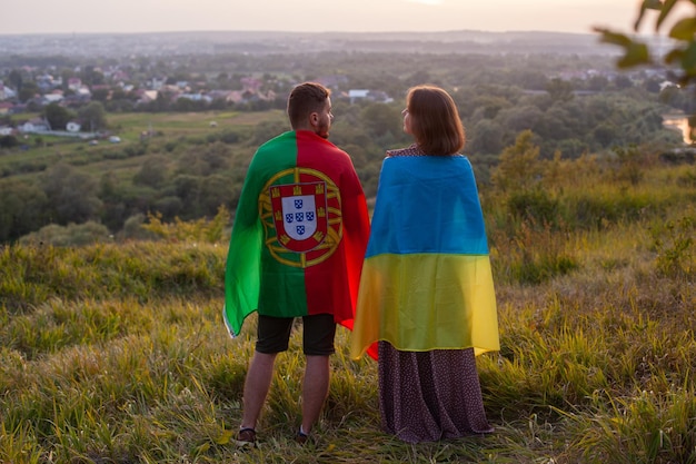 Couple covered in Ukraine and Portugal flags