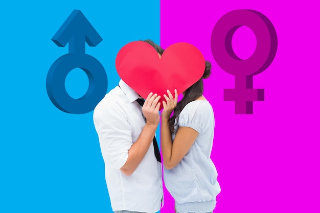Couple covering their kiss with a heart against pink and blue