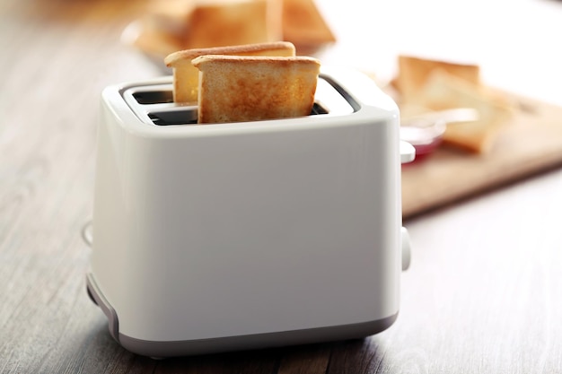 Photo a couple of crusty toast in the toaster on the table closeup