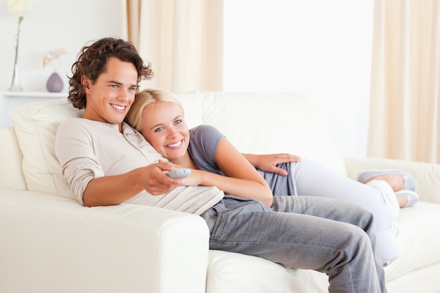 Couple cuddling while watching TV