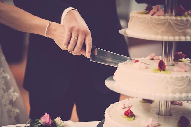 A couple cutting a wedding cake with a knife