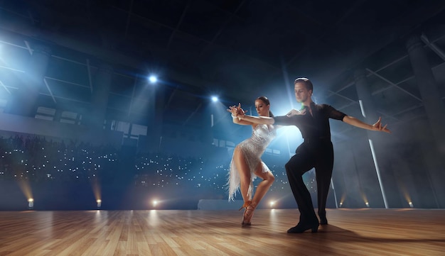 Couple dancers perform latin dance on large professional stage Ballroom dancing