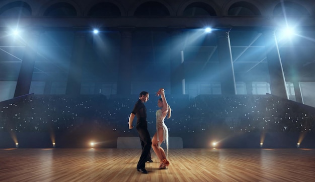 Couple dancers perform latin dance on large professional stage Ballroom dancing