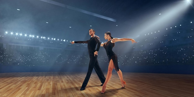 Couple dancers perform latin dance on large professional stage Ballroom dancing