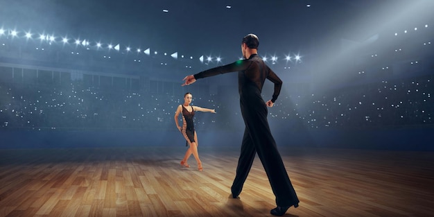 Couple dancers perform latin dance on large professional stage Ballroom dancing