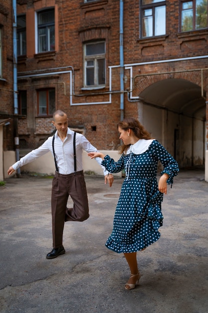 写真 屋外で一緒に踊るカップル フルショット