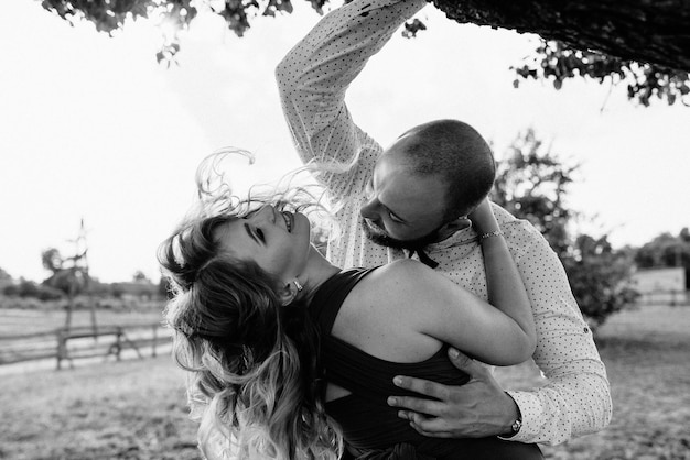 Couple on a date. purple dress. bride and groom. walk in the
field. love story. black and white photo.