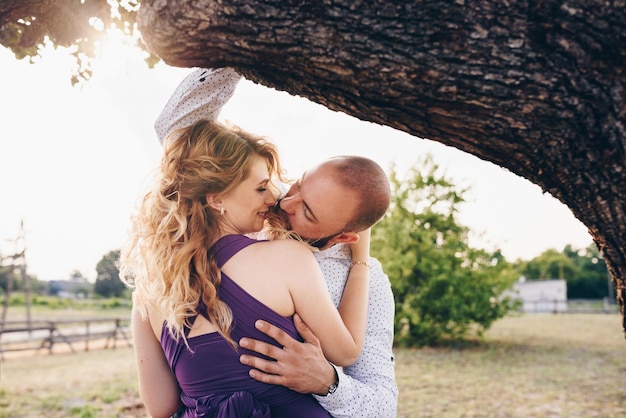 Coppia ad un appuntamento. vestito viola. sposa e sposo. cammina nel campo. storia d'amore.