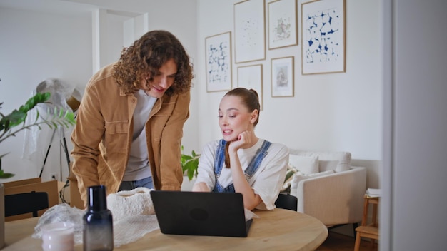 couple discussing internet store on laptop planning decor new home closeup