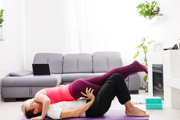 Coppia facendo esercizi a casa. concetto di yoga.