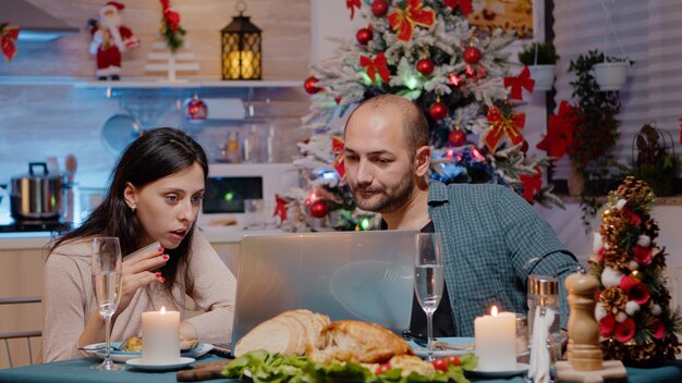 Couple doing online shopping on laptop with credit card