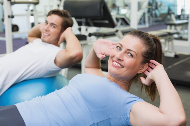 Couple doing sit ups on exercise balls