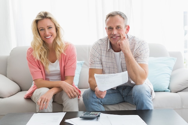 Couple doing their accounts sat in a couch