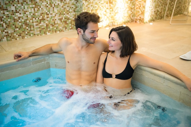 Foto coppia che fa un bagno a vasca idromassaggio in una spa