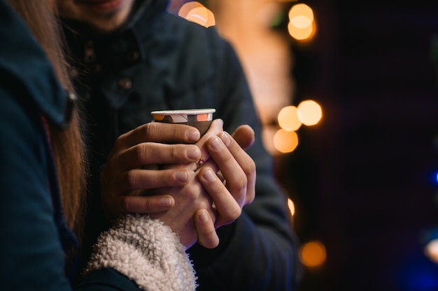 Photo couple drink coffee at the new year fair
